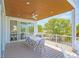 Inviting covered balcony featuring modern dining furniture, ceiling fan, and neighborhood views at 630 Companion Way, Longboat Key, FL 34228
