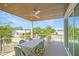 Relaxing covered balcony with dining furniture, ceiling fan, and views of the surrounding neighborhood at 630 Companion Way, Longboat Key, FL 34228