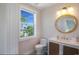 Stylish bathroom with a round mirror, decorative vanity, and a bright window with a view at 630 Companion Way, Longboat Key, FL 34228