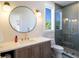 Modern bathroom featuring a vanity with a round mirror, a toilet, and a glass-enclosed shower at 630 Companion Way, Longboat Key, FL 34228