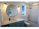 Modern bathroom featuring sleek vanity, large round mirror, and tub with shower, showcasing contemporary design at 630 Companion Way, Longboat Key, FL 34228