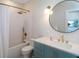 Modern bathroom with vanity, round mirror, and textured tile, plus gold hardware at 630 Companion Way, Longboat Key, FL 34228