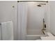 Well-lit bathroom showcasing bronze shower fixtures, a white shower curtain, and a decorative textured wall at 630 Companion Way, Longboat Key, FL 34228