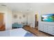 Bright bedroom featuring hardwood floors, a modern TV, and stylish decor at 630 Companion Way, Longboat Key, FL 34228