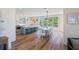 Bright dining room featuring a large picture window, wood floors, and modern furnishings at 630 Companion Way, Longboat Key, FL 34228