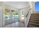 Bright entryway with staircase and sliding glass doors leading to the pool and outdoor area at 630 Companion Way, Longboat Key, FL 34228