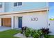 Close-up of the home's address (630) with a striking blue door and meticulous landscaping, creating a welcoming entrance at 630 Companion Way, Longboat Key, FL 34228