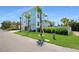 Three-story coastal home featuring a charming balcony and a two-car garage, bordered by well-maintained greenery at 630 Companion Way, Longboat Key, FL 34228