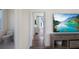 Hallway with wood floors and white walls leads to a bathroom and a room with outdoor access at 630 Companion Way, Longboat Key, FL 34228