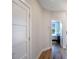 Inviting hallway with hardwood floors and white doors, leading to a bedroom with natural light at 630 Companion Way, Longboat Key, FL 34228