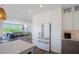 Modern kitchen with white cabinets, unique hardware, and stainless steel appliances adjacent to the living area at 630 Companion Way, Longboat Key, FL 34228
