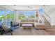 Comfortable living room area with large windows, a neutral sofa, and access to an outdoor balcony at 630 Companion Way, Longboat Key, FL 34228