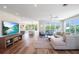 Bright, open-concept living room features hardwood floors, modern furnishings, and sliding glass doors to the outside at 630 Companion Way, Longboat Key, FL 34228