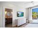 Bedroom with a large bed, TV, dresser, and ensuite bathroom featuring a decorative mirror at 630 Companion Way, Longboat Key, FL 34228