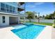 Relax by the pool in the backyard oasis with a connected spa, promising endless summer fun and relaxation at 630 Companion Way, Longboat Key, FL 34228