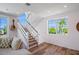 Modern staircase with wood treads, white risers, and a scenic view through the window at 630 Companion Way, Longboat Key, FL 34228