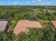 Aerial view of home featuring tile roof, screened lanai, and picturesque lush landscape at 790 Shadow Bay Way, Osprey, FL 34229