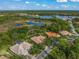 An aerial perspective displays the home near a tranquil lake surrounded by trees at 790 Shadow Bay Way, Osprey, FL 34229
