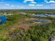 Expansive aerial view showcasing the community's lush landscaping and serene lake at 790 Shadow Bay Way, Osprey, FL 34229