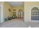 Inviting front porch featuring a tiled patio, seating, and beautiful double door entry at 790 Shadow Bay Way, Osprey, FL 34229