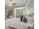 Bright main bedroom featuring a ceiling fan, slider door access to patio, and sitting area by the window at 790 Shadow Bay Way, Osprey, FL 34229
