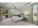 Serene main bedroom featuring a sitting area, plush carpet, and ample natural light from the sliding doors at 790 Shadow Bay Way, Osprey, FL 34229