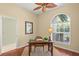 Cozy office with desk, hardwood floors, and arched window at 790 Shadow Bay Way, Osprey, FL 34229