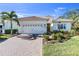 Beautiful home with tile roof, palm tree, brick driveway, and well-maintained landscaping at 11816 Altamonte Ct, Venice, FL 34293