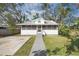 Charming home with a screened front porch, mature trees, and a well-maintained front lawn at 1717 32Nd St, Sarasota, FL 34234