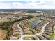 Wide aerial view shows tile-roofed homes surrounding a community lake, and lush nature preserve at 20289 Benissimo Dr, Venice, FL 34293