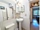 Modest bathroom features pedestal sink, wainscotting, and view into adjacent bedroom at 2075 Canal Dr # L36, Bradenton, FL 34207