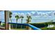 Balcony view featuring palm trees, lush landscaping, blue sky and water view at 2110 Harbourside Dr # 526, Longboat Key, FL 34228