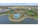 Community pool and clubhouse overlook a lake, surrounded by tropical landscaping and upscale homes at 328 Aria Dr, Nokomis, FL 34275