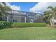 Backyard area with screened-in porch and green landscape at 328 Aria Dr, Nokomis, FL 34275