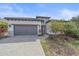 Beautiful single Gathering home featuring a paved driveway, gray garage doors, and colorful landscaping at 328 Aria Dr, Nokomis, FL 34275