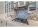 Detailed view of the kitchen featuring a modern gas range, stylish vent hood, and shimmering tile backsplash at 328 Aria Dr, Nokomis, FL 34275
