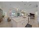 Open kitchen flows into dining and living areas, featuring an island with bar seating and views of the backyard at 328 Aria Dr, Nokomis, FL 34275