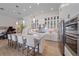 Spacious kitchen featuring a center island with bar seating, white cabinetry, and modern stainless steel appliances at 328 Aria Dr, Nokomis, FL 34275