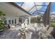 Spacious screened patio with comfortable seating, firepit, and serene lake views at 328 Aria Dr, Nokomis, FL 34275