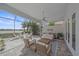 Spacious screened patio with comfortable seating, ceiling fan, and serene lake views at 328 Aria Dr, Nokomis, FL 34275