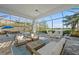 Spacious covered patio with plush seating, dining area, and views of the sparkling pool and serene lake at 328 Aria Dr, Nokomis, FL 34275