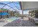 A screened in pool and outdoor patio with view of lake, chairs and patio furniture at 328 Aria Dr, Nokomis, FL 34275