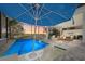 Beautiful backyard at sunset with a screened in pool, umbrella, seating and view of the lake at 328 Aria Dr, Nokomis, FL 34275