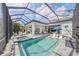Beautiful backyard with a screened in pool, jacuzzi, seating and view of the lake at 328 Aria Dr, Nokomis, FL 34275