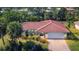 Charming single-story home featuring a red tile roof, lush landscaping, and an attached two-car garage at 395 W Rossetti Dr, Nokomis, FL 34275