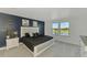 Main bedroom with a navy accent wall, view from windows and large bed with grey patterned pillows at 6284 Talon Preserve Dr, Nokomis, FL 34275