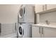 Bright laundry room features modern, stacked washer and dryer with utility sink and storage at 111 S Pineapple Ave # 708, Sarasota, FL 34236