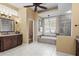 A bathroom featuring a soaking tub, walk-in shower, and a dark wood vanity at 2611 Little Country Rd, Parrish, FL 34219