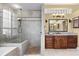 Bathroom featuring a large walk-in shower, with a dark wood vanity, and large mirror at 2611 Little Country Rd, Parrish, FL 34219
