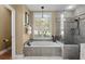 Bright bathroom showcases a luxurious soaking tub, walk-in shower, and neutral color palette at 2611 Little Country Rd, Parrish, FL 34219